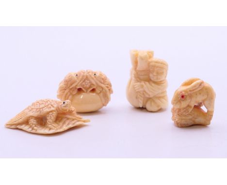 Four bone carvings: one a hare/rabbit, a pair of dogs-of-fo, a tortoise and a man holding a large bag.  Man with bag netsuke 