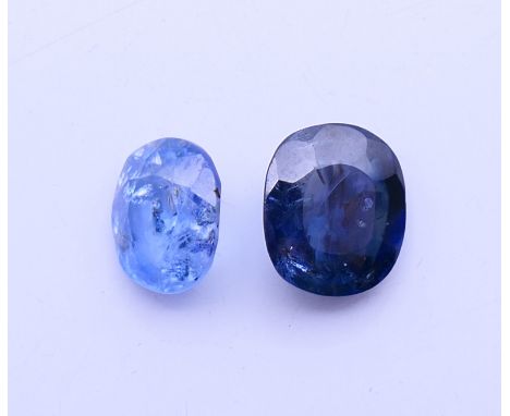 Two loose sapphires.  Dark blue sapphire 1 cm high, light blue sapphire 8 mm high.
