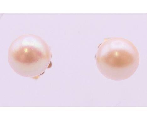 A pair of 14 K gold pearl earrings.  Approximately 6mm diameter.