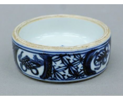 A Chinese Kangxi-style small cylindrical blue and white-glazed ceramic inkstone. 8 cm diameter.
