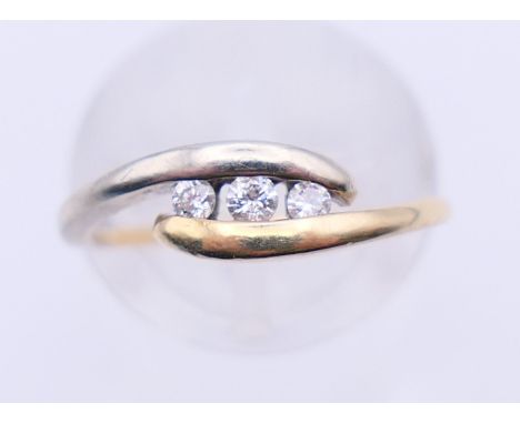 A 9 ct bi-gold three-stone diamond ring.  Ring size K/L.