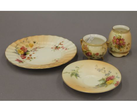 Four pieces of Royal Worcester blush ivory porcelain including a plate, a saucer, a small bud vase and a small cauldron-form 
