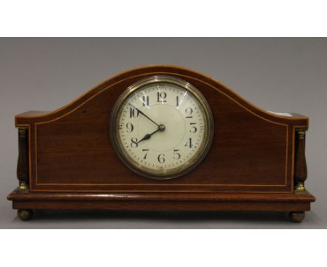 An inlaid Edwardian mahogany eight-day mantle clock with enamel dial and French movement. 29.5 cm wide.