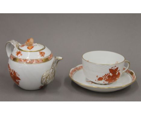 A Herend porcelain teapot and a cup and saucer. The former 16.5 cm long.