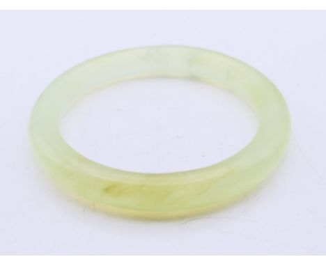 A pale green hardstone bangle. 8 cm external diameter, 6 cm internal diameter, 1 cm wide. 