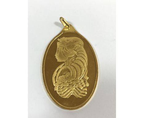 SUISSE ONE TROY OUNCE. An ingot/pendant decorated with a female portrait, the reversw 'Suisse One Troy Ounce 999.9 Fine Gold,