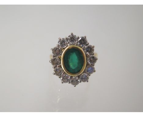 An 18ct yellow gold emerald and diamond cluster ring, head size approx 19mm x 17mm, emerald approx 8.5mm x 6mm x 4mm, approx 