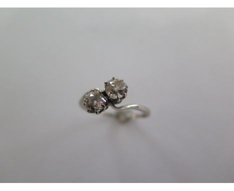 A two stone diamond crossover ring possibly platinum, each diamond approx 0.45ct - one diamond has chips and possible fractur