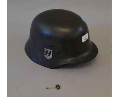 Reproduction German WWII helmet together with a related pin badge (2)