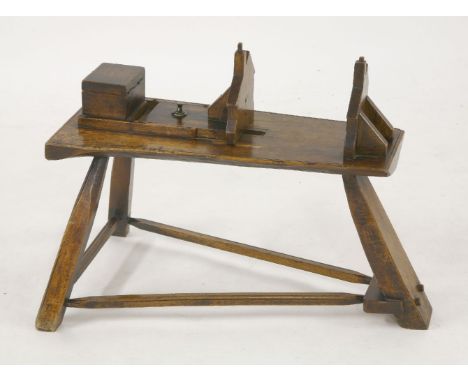 An unusual elm bench,of unknown use, the top with two fret cut house profiles, one adjustable, and with a lidded compartment,