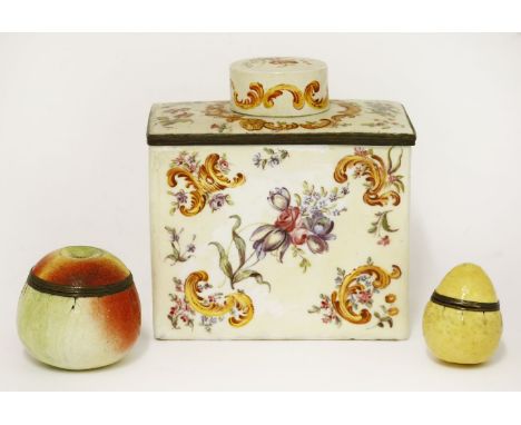 An enamel tea caddy and cover,19th century, painted with flowering foliage on a pale ground,12cm high, andtwo fruit-shaped en
