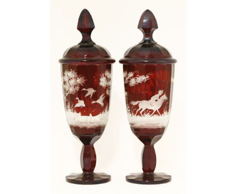 A pair of Bohemian ruby glass Jars and Covers,late 19th/early 20th century, etched with deer, a figure on horseback and ducks