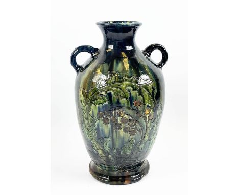 C.H. BRANNAM BURUMWARE POTTERY VASE, incised decoration of leaves and berries in blue, green, ochre glaze, inscribed to base,