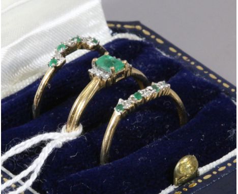 A suite of three gold rings set with diamonds and emeralds size R.