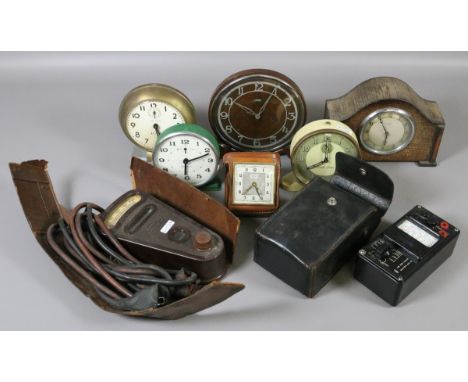 Six vintage clocks including cased alarm clock and an Art Deco oak Metamec mantle clock along with a Bakelite ignition tester