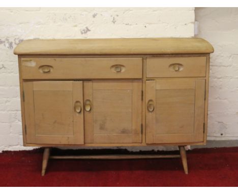 An Ercol Golden Dawn sideboard raised on turned supports.