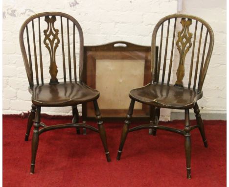 A pair of oak wheelback kitchen chairs with pierced splats and crinoline stretchers, along with an oak firescreen frame.
