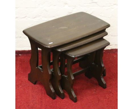 A nest of three Ercol mahogany tables.