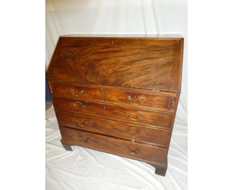 A George III mahogany bureau with internal drawers and pigeonholes enclosed by a fall front above two short and three long dr