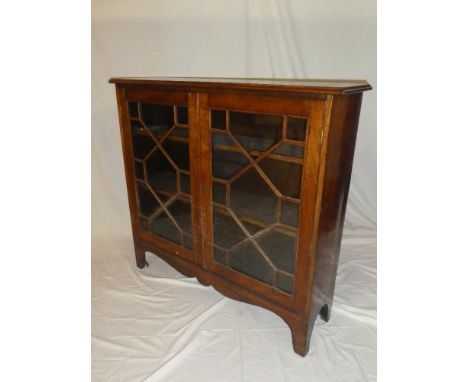 A late Victorian/Edwardian mahogany bookcase with adjustable shelves enclosed by two astragal glazed doors on bracket feet