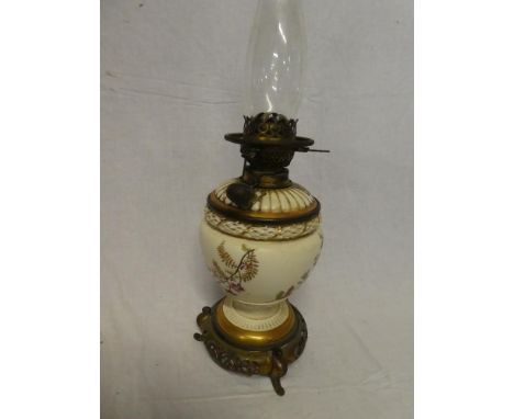 A Victorian brass mounted pottery oil lamp with detachable glass font and floral decoration on pierced base