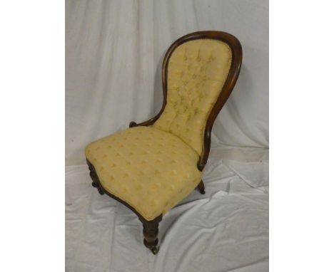 A Victorian mahogany ladies easy chair upholstered in button fabric on turned legs