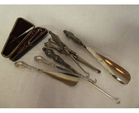A selection of silver handled button hooks, shoe horns, glove stretcher, etc