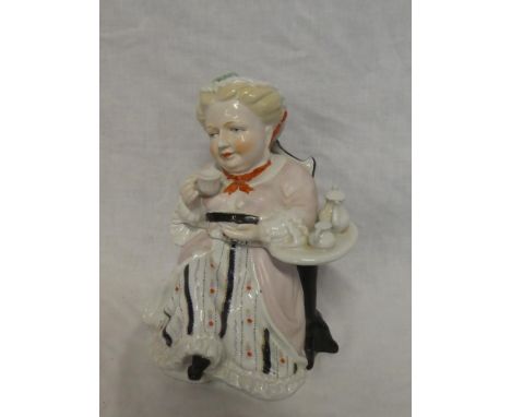 A Continental china tea caddy in the form of a seated female drinking tea 8" high