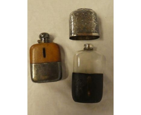 A silver plated and leather covered glass hip flask with engraved decoration and one other similar hip flask with hinged lid 