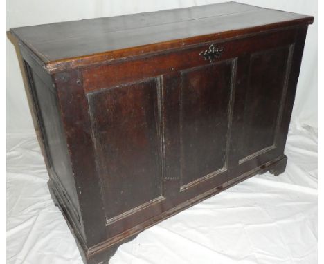 An early 19th Century oak rectangular coffer with triple panelled front and internal candle box enclosed by a hinged lid on b