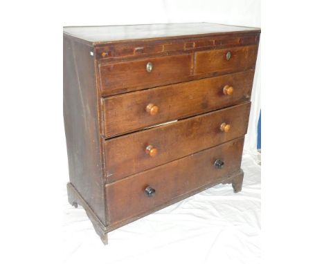 A George III oak and mahogany cross banded chest of two short and three long drawers with turned handles on bracket feet