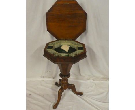 A Victorian walnut octagonal work table with fitted interior enclosed by a hinged lid on tripod base (af)