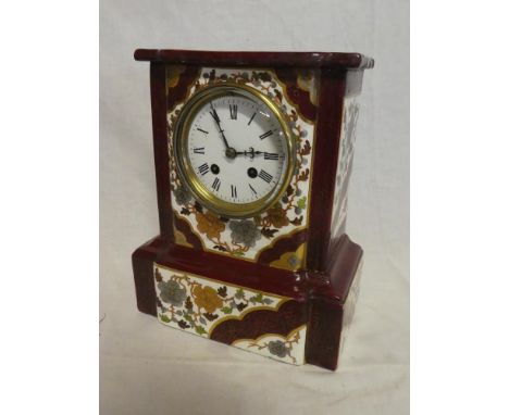 A Victorian mantel clock with enamelled circular dial in floral decorated ceramic rectangular case