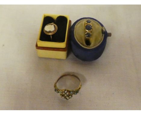 An 18ct gold dress ring set blue stones (damaged); 9ct gold dress ring set cameo emblem and one other turquoise mounted dress
