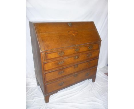 A George III oak and mahogany cross banded bureau with fitted interior enclosed by a fall front above four long graduated dra