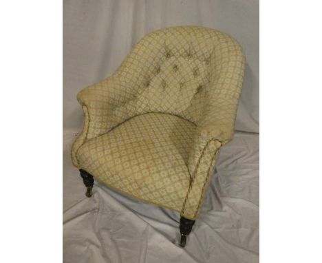 A Victorian tub-style easy chair upholstered in button fabric on turned legs and brass casters