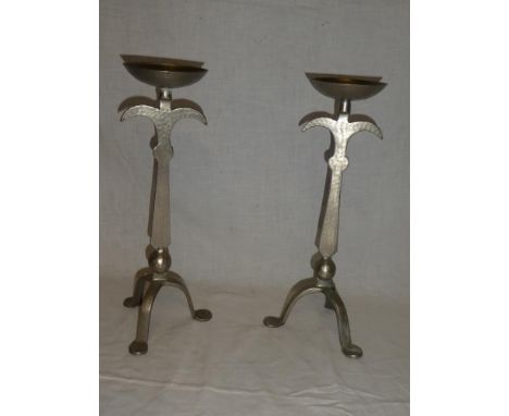 A pair of Arts &amp; Crafts style beaten steel candlesticks on tripod bases 