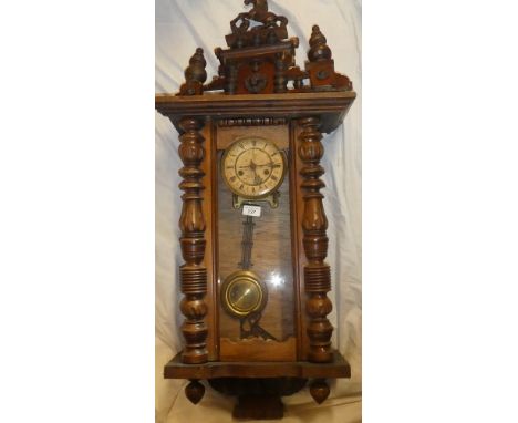 A Vienna-style wall clock with circular dial in polished mahogany glazed case with turned supports and horse finial