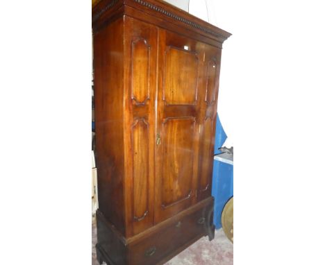 A late Victorian mahogany wardrobe with hanging compartment enclosed by a central panelled door above a drawer in the base su