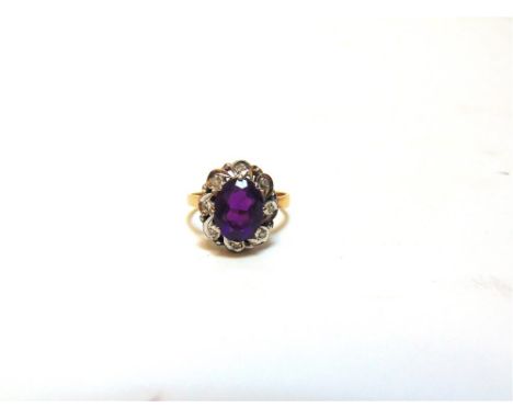 AN AMETHYST AND DIAMOND 18 CARAT GOLD RING  the oval out stone enclosed by eight simple cut diamonds, finger size O1/2, 4.2g 