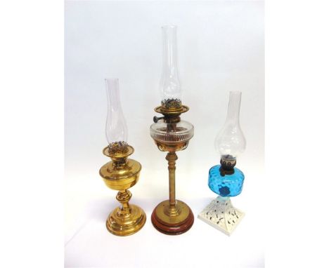 A VICTORIAN OIL LAMP  with clear cut glass reservoir, on brass column and oak base, 72.5cm high; together with two further oi