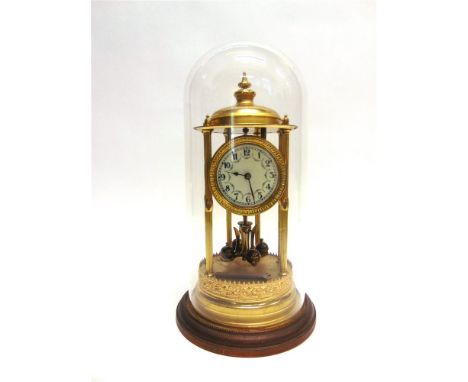 A LATE 19TH CENTURY BRASS ANNIVERSARY CLOCK the circular white enamel dial with black Arabic numerals, beneath a glass dome, 