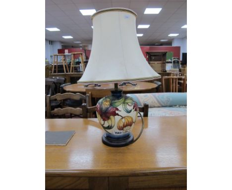 A Moorcroft Pottery Table Lamp, painted in the 'Anna Lily' design by Nicola Slaney, 18cm high, with wooden base and cream sha