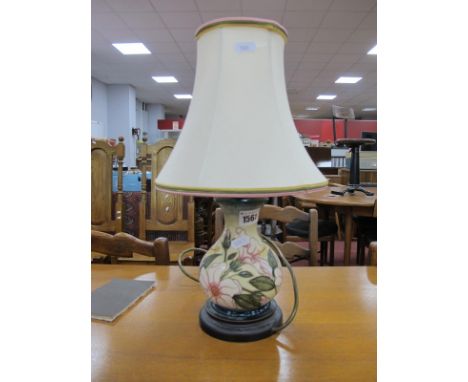 A Moorcroft Pottery Table Lamp, painted with s design of pink flowers, 16.5cm high,on wooden base with cream shade.