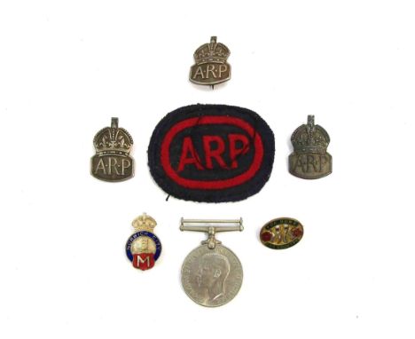 A WWII Defence medal, ARP cloth badge and three silver examples, Women's Land Army "For Home and Country" badge, and another 