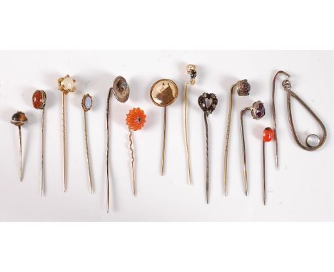 Thirteen assorted stick pins: to include tigers eye, goldstone, moonstone, faux opal, faux amethyst, a paste set heart, etc, 