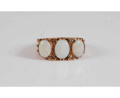 A 9ct opal and diamond ring, the three oval opal cabochons, set with diamond highlights, to a scrolled gallery and tapered ba
