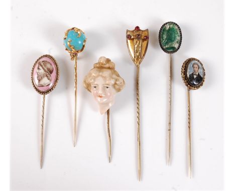 Six various stick pins: to include a stick pin of a 3-dimensional ceramic bust of a lady, 22mm wide; a paste set shield stick