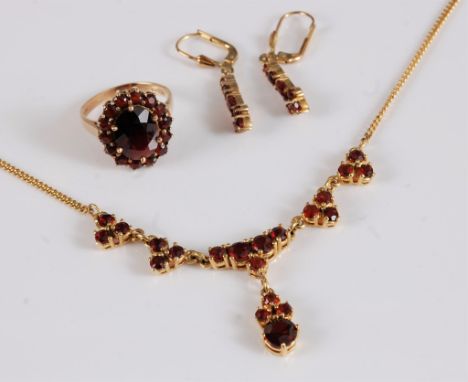 A 9ct garnet suite, comprising of a necklace, 63mm wide, drop 23mm long, overall length 36.5cm long, a garnet cluster ring, 1