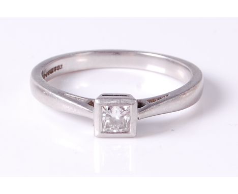 A platinum diamond solitaire ring, the princess cut diamond in a rubover setting, weighing approx 0.25ct, 4.6g, size O